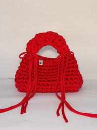 Bright red bobble-stitch crochet bag with a chunky top handle and bows at each side