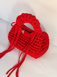 Bright red bobble-stitch crochet bag with a chunky top handle and bows at each side