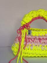 Neon yellow bobble-stitch crochet bag banded with blush, with a chunky top handle and bows