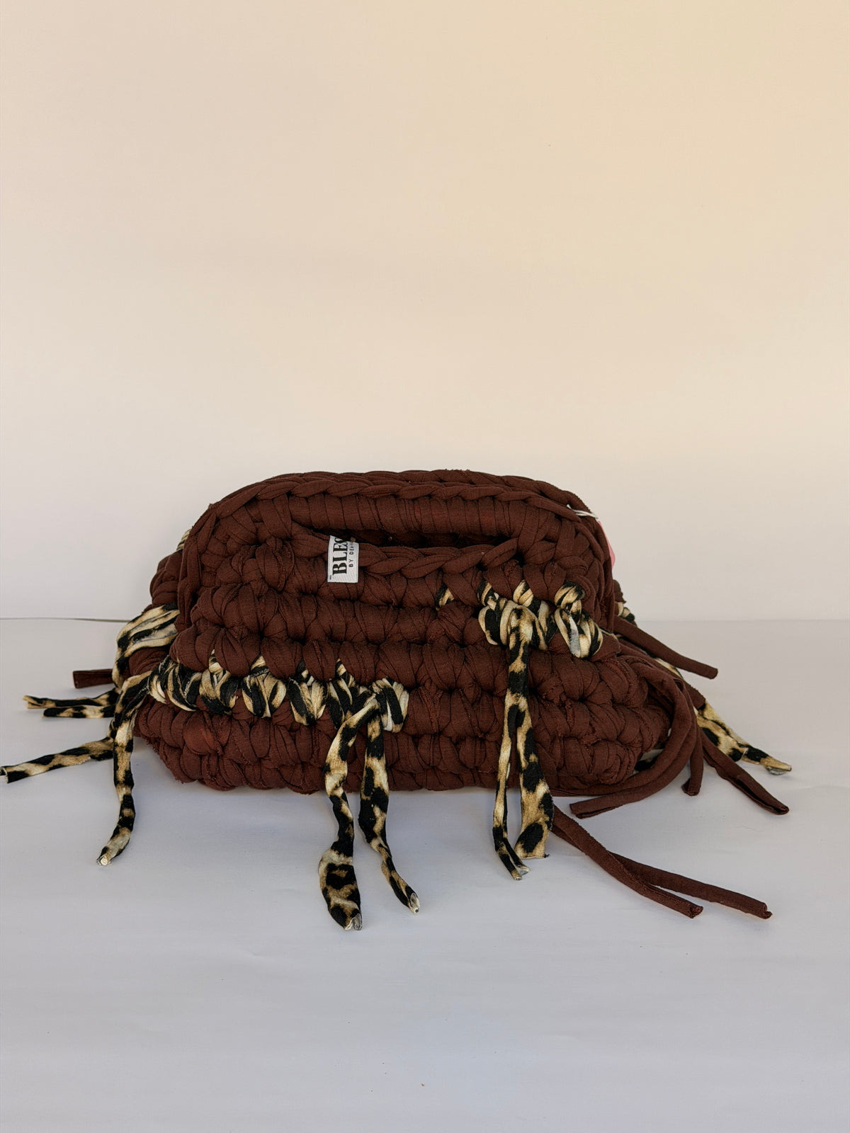 Warm brown crochet clutch with a leopard-print fringe and integrated top handle