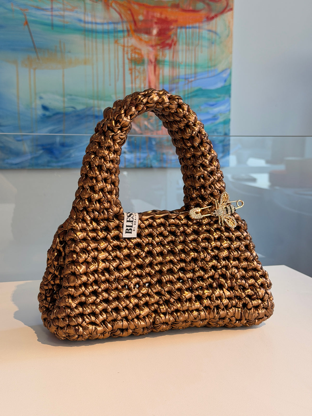 Antique gold metallic crochet purse by Blessed by Dea-Victoria, held by the top handle