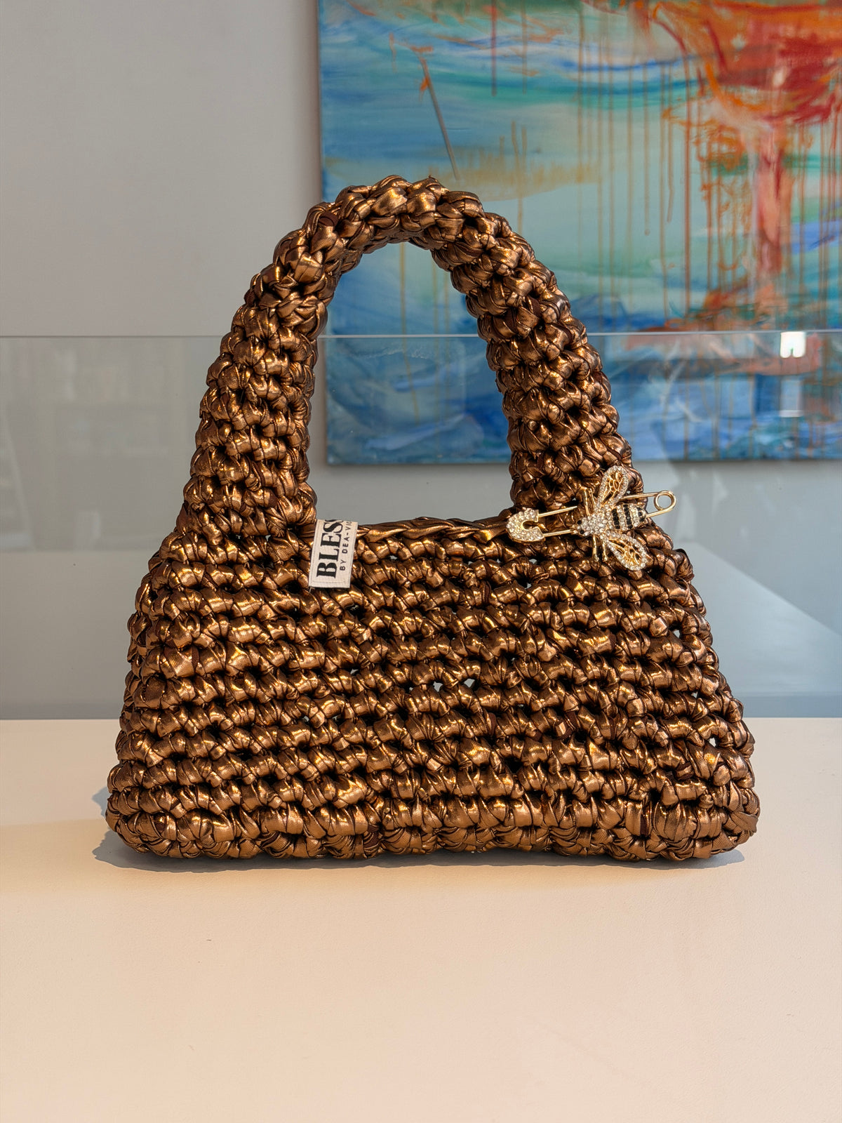 Handmade crochet Suki purse in antique gold metallic yarn with a crystal bee pin