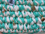 Seaglass green and cream striped crochet bag with a braided top handle and gold shell charms