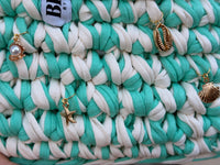 Seaglass green and cream striped crochet bag with a braided top handle and gold shell charms