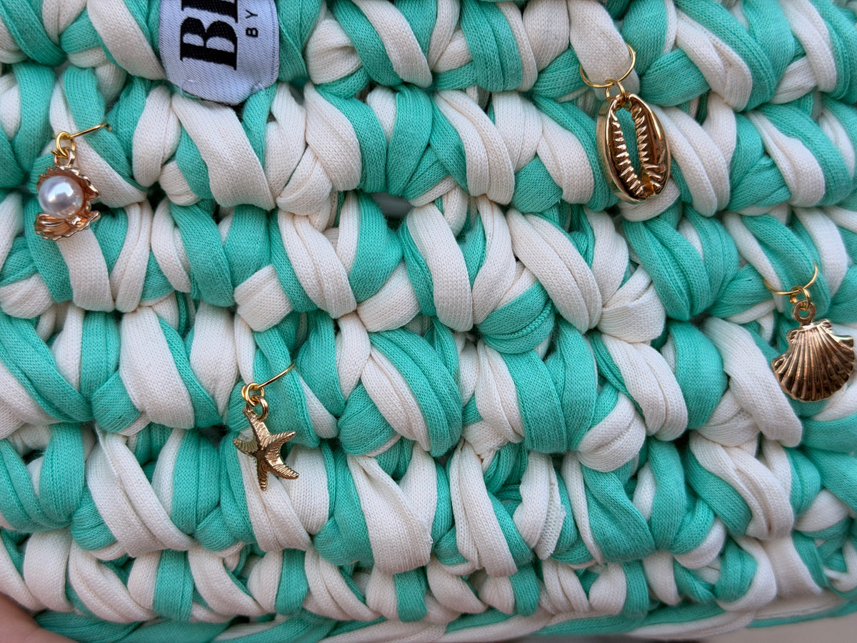 Seaglass green and cream striped crochet bag with a braided top handle and gold shell charms