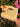 Golden yellow and cream crochet bag with a braided top handle and a yellow flower