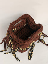 Warm brown crochet clutch with a leopard print band and leopard ties, woven Blessed label visible