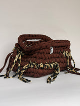 Open top of a warm brown crochet clutch with leopard print ties around the base