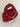 Deep red chunky crochet bag with a braided top handle and a gold charm chain of hearts across the front
