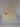 Cream chunky crochet bag with a braided top handle and a gold brooch of pearl, bow and flower charms