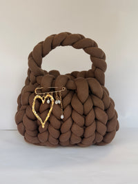 Gold hammered heart brooch with pearl drops pinned to a chunky brown crochet bag