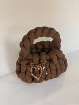 Chunky brown crochet bag with a braided top handle and a gold heart and pearl brooch
