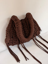 Close view of the woven Blessed label on a deep brown crochet shoulder bag