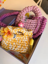 Golden yellow and cream crochet bag with a braided top handle and a yellow flower