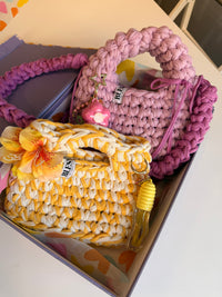 Golden yellow and cream crochet bag with a braided top handle and a yellow flower