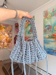 Pale grey crochet shoulder bag with braided top handle and long side ties
