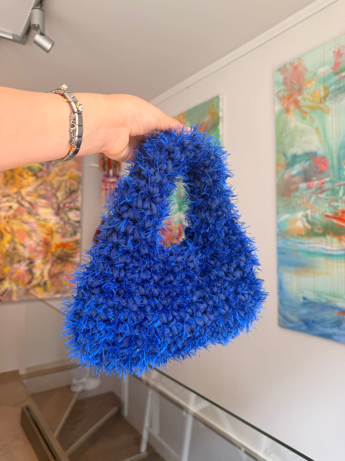 Electric blue crochet shoulder bag with an integrated cut-out handle