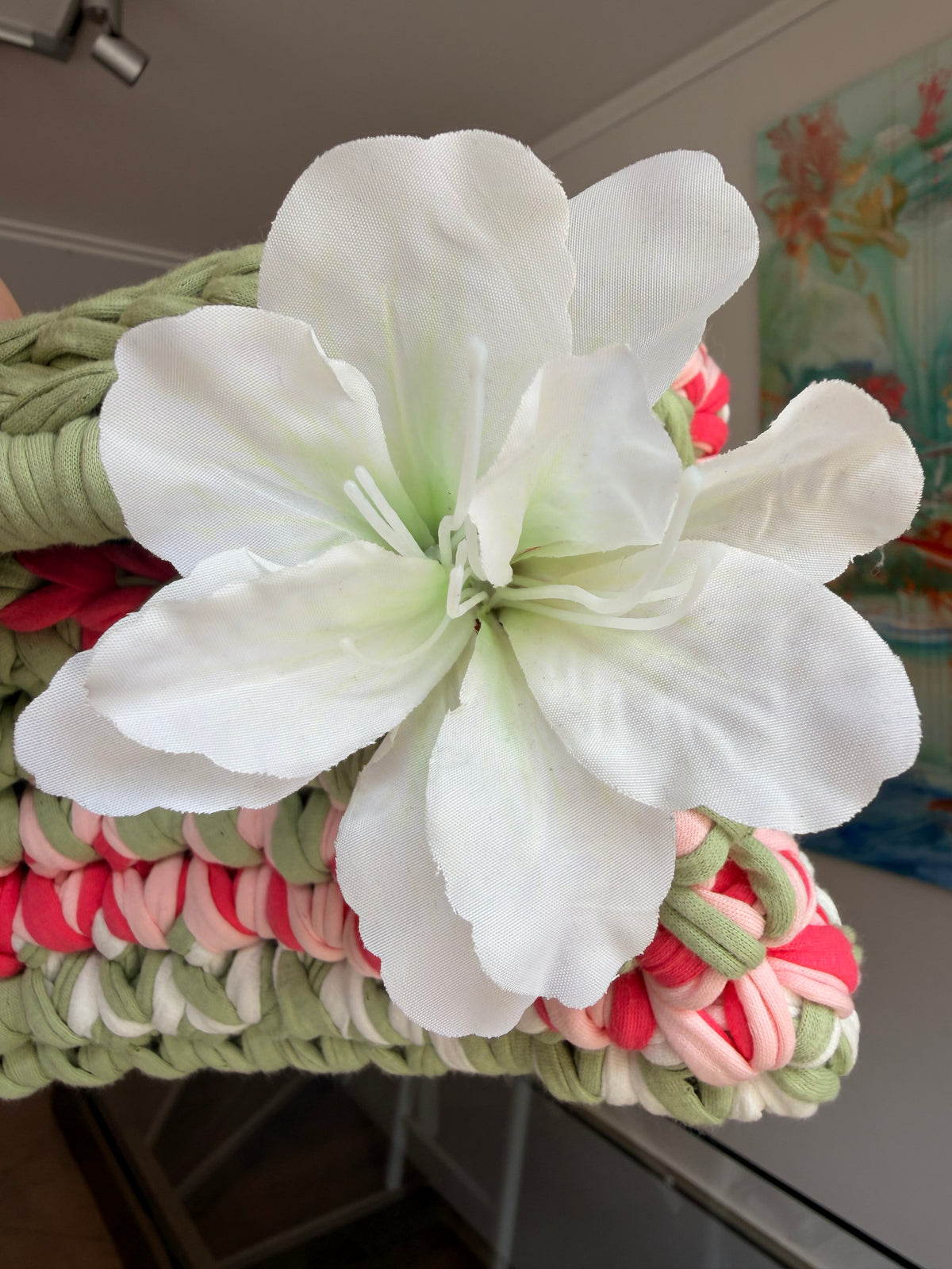 Sage green crochet clutch with a raspberry and cream stripe and a silk flower at the handle