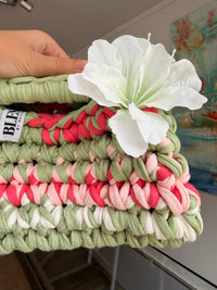 Sage green crochet clutch with a raspberry and cream stripe and a silk flower at the handle