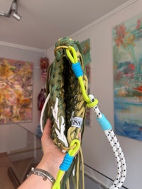 Olive green crochet crossbody bag with a corded strap and long fringe