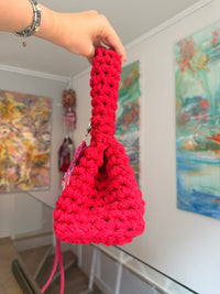 Bright red crochet bag with a wide top handle, long ties and a beaded jellyfish charm