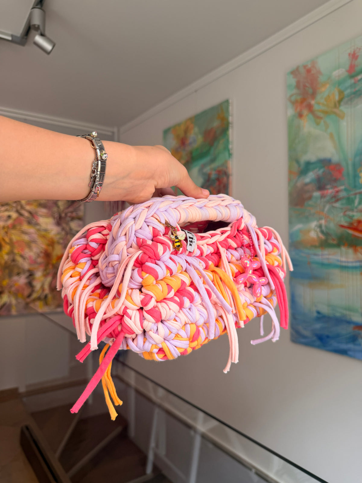 Multicoloured crochet clutch in coral, lilac, peach and apricot with a fringe all round