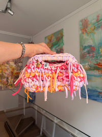 Multicoloured crochet clutch in coral, lilac, peach and apricot with a fringe all round