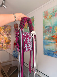 Berry and pale grey crochet bag with a braided top handle, cream bow and long fringe