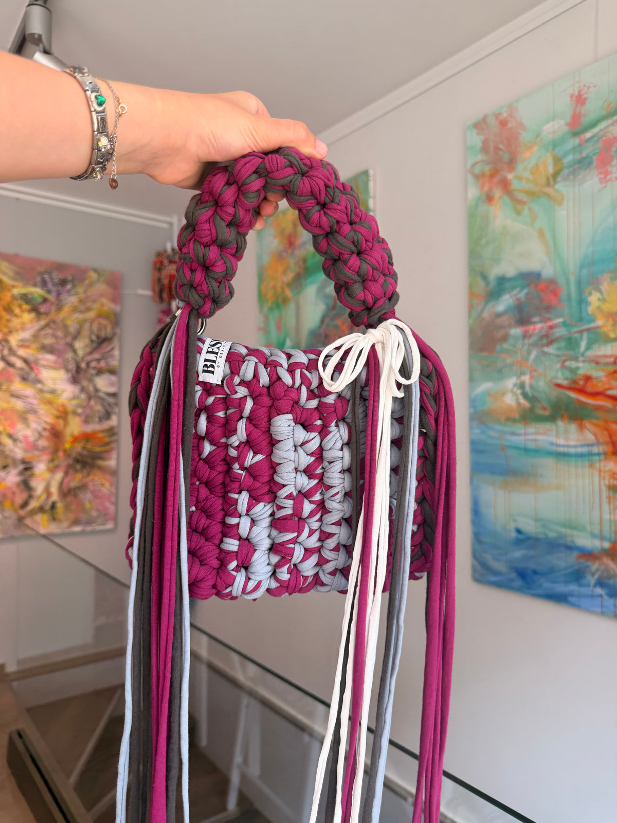 Berry and pale grey crochet bag with a braided top handle, cream bow and long fringe