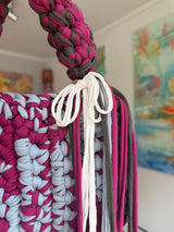 Berry and pale grey crochet bag with a braided top handle, cream bow and long fringe
