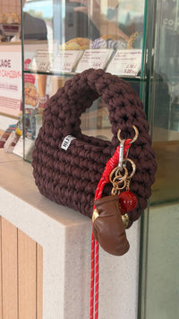 Deep plum-brown crochet bag with a rounded top handle