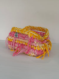 Close-up of the chunky cotton tube yarn stitch in pink, cream and marigold