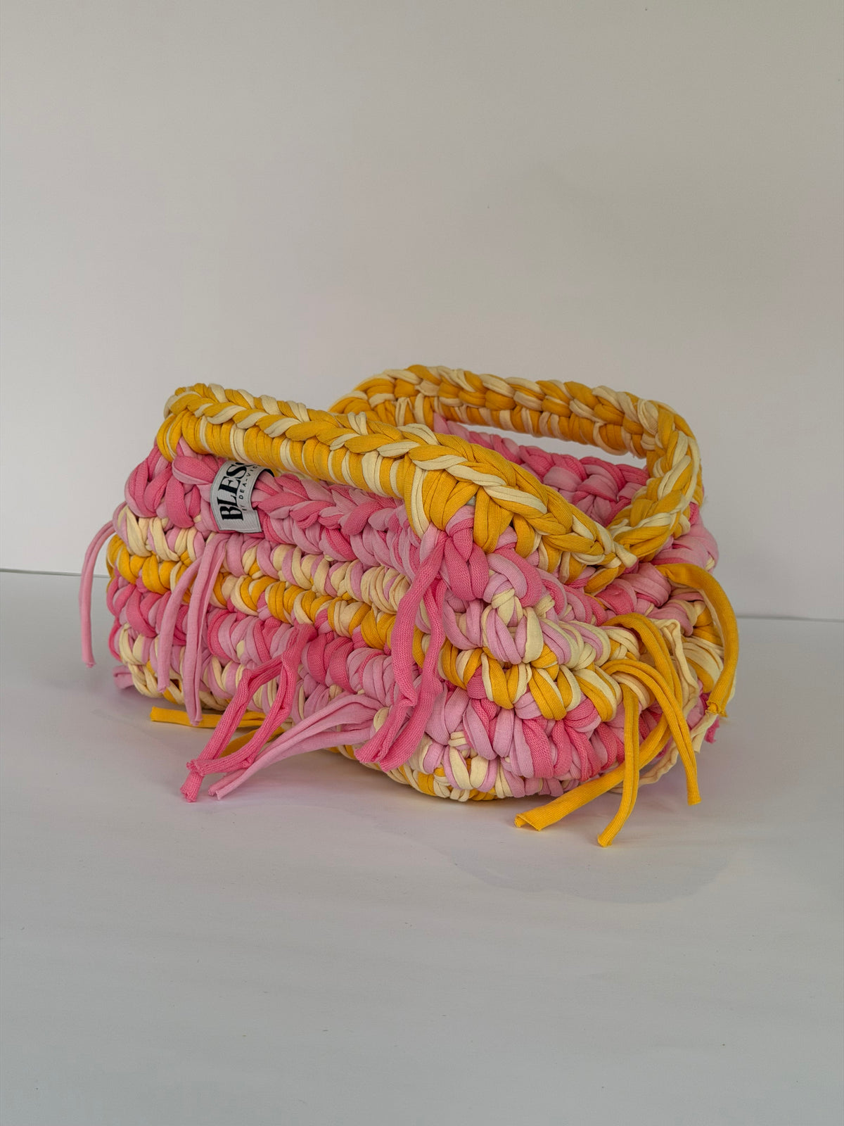 Close-up of the chunky cotton tube yarn stitch in pink, cream and marigold