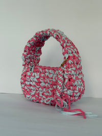 Pink and pale blue crochet shoulder bag with a big rounded handle, gold clasp and long ties