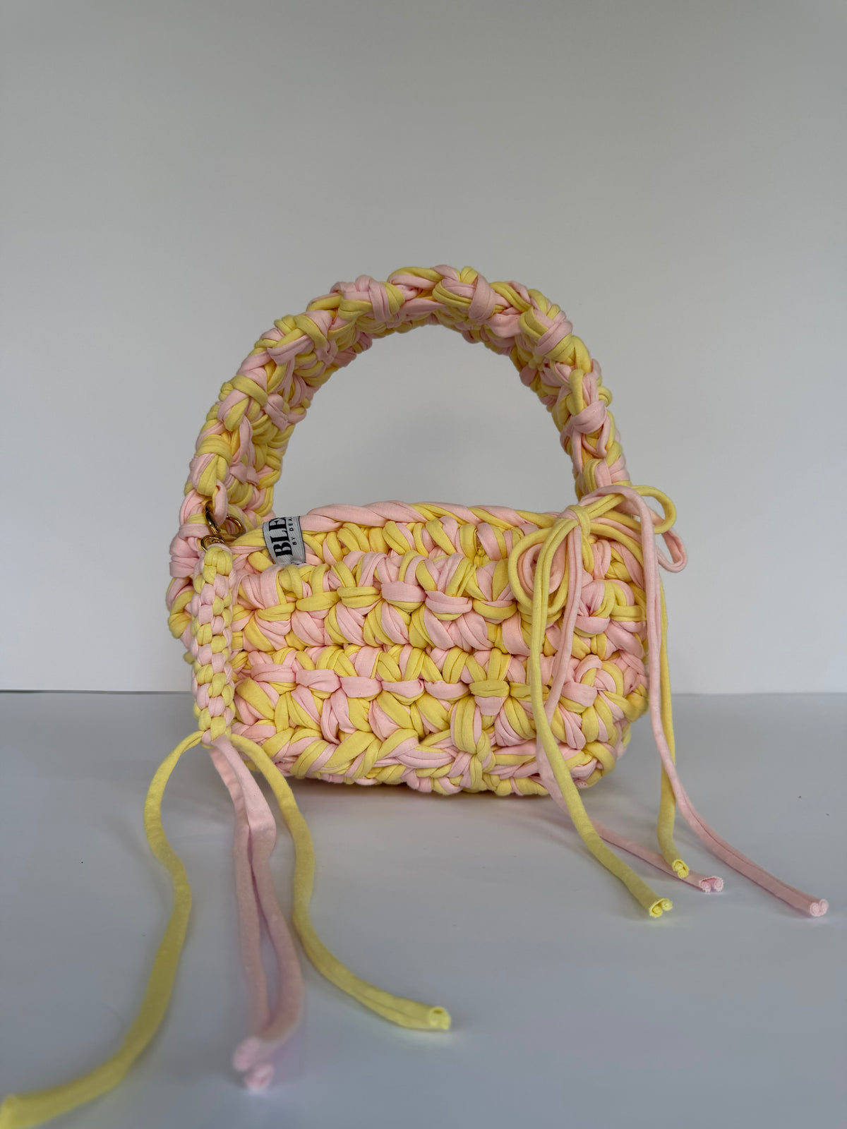 Lemon and pink crochet bag with a big rounded handle, gold heart clasp and long ties
